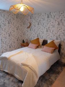 a bedroom with a white bed with pink pillows at LA CAMPAGNE in Dontreix