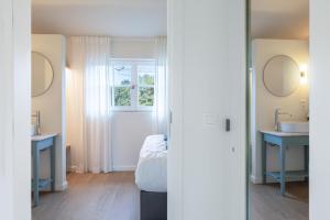 a bathroom with two sinks and a window at Boonackere Cottage in Oosterzele