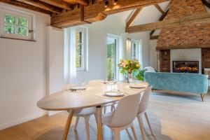 a dining room with a table and chairs and a fireplace at Boonackere Cottage in Oosterzele +38 photos