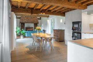 a kitchen and dining room with a table and chairs at Boonackere Cottage in Oosterzele