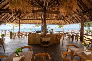 a restaurant on the beach with tables and chairs at Relax Bay Beach Resort in Ko Lanta