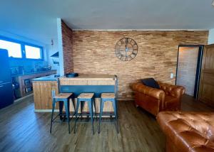 a kitchen with a bar with stools and a couch at COAST HOUSE Havenquartier in Bremerhaven +31 photos