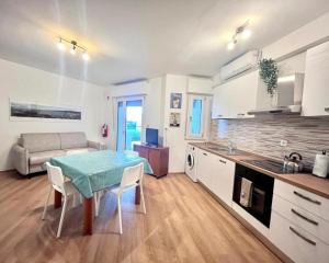 a kitchen and living room with a table and a couch at JuliaHome in Marina Julia