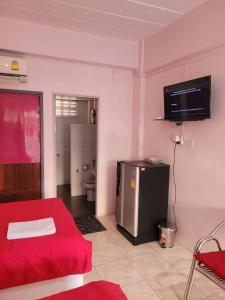 a living room with a red couch and a television at ลพบุรีทาวน์ Lopburi Town in Lop Buri