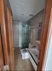 a bathroom with a shower and a toilet and a sink at Nicholas Residence in Silang