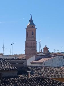 a clock tower on top of a building with roofs at Casa Rural Forcén in Lumpiaque
