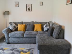 a living room with a gray couch with orange pillows at Carolyn House in Ellington