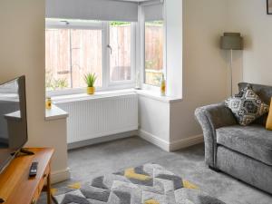 a living room with a couch and a window at Carolyn House in Ellington