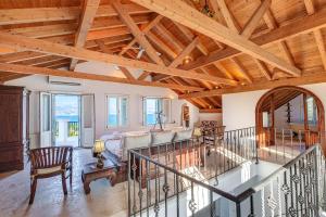 a large living room with wooden ceilings and a staircase at Eagle's Rest Villa in Kassiopi