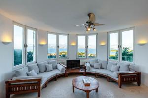 a living room with white furniture and large windows at Eagle's Rest Villa in Kassiopi