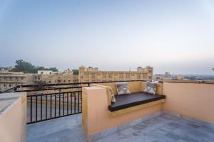 a bench on a balcony with a view of a city at Shri Prem Villa in Jaisalmer