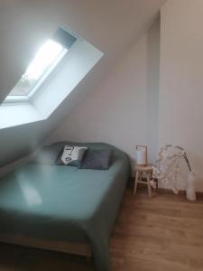 a bedroom with a green bed in a attic at l'auberge des trois lieux in Calais