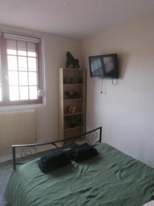 a bedroom with a bed and a flat screen tv at l'auberge des trois lieux in Calais