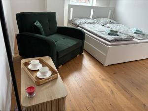 a small room with a bed and a chair and a table at TatryForRest in Starý Smokovec