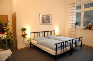 a bedroom with a bed with blue sheets and a window at Nassauer Hof in Sankt Goarshausen