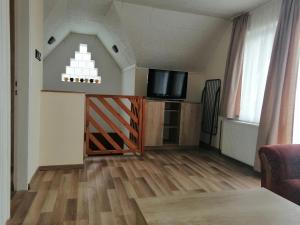a living room with a tv and a wooden floor at Vadrózsa Nyaraló in Balatongyörök