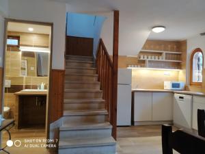 a staircase leading up to a kitchen with a stair case at Vadrózsa Nyaraló in Balatongyörök +7 photos