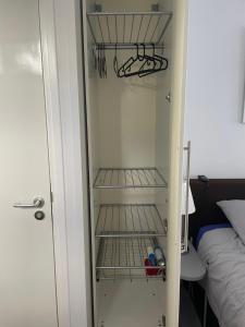 a small refrigerator with shelves in a room at Gastenverblijf Buitenplaats Wergea contactloos inchecken in Naarderburen