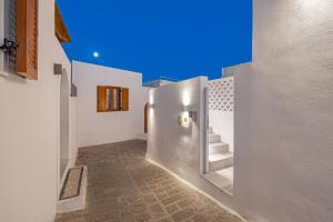 a hallway with white walls and stairs in a building at Kantouni Lindos ELEGANT APARTMENT in Lindos