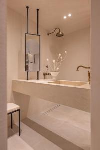 a bathroom with a tub and a sink and a mirror at Kantouni Lindos ELEGANT APARTMENT in Lindos +14 photos