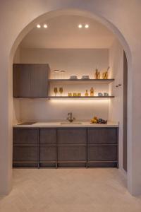 an archway in a kitchen with a sink at Kantouni Lindos ELEGANT APARTMENT in Lindos