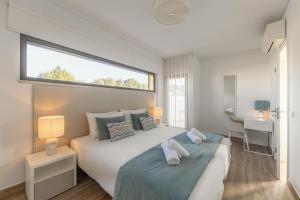 a bedroom with a large bed with two towels on it at Silver Coast Haven in Coto