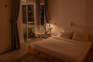 a bedroom with a bed and a window with a chair at The LOOP Boutique Hotel & Café in Da Lat