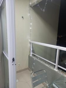 a bathroom with a shower with a chair next to a window at Paraiso Ponta de Campina in Cabedelo +8 photos