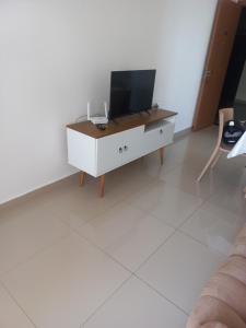 a living room with a tv on a white cabinet at Paraiso Ponta de Campina in Cabedelo