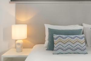 a bedroom with a bed with a pillow and a lamp at Silver Coast Haven in Coto