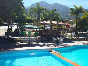 a swimming pool with tables and chairs in a resort at Jarabacoa River Club & Resort in Jarabacoa +12 photos