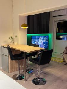 a dining room with a table and chairs and a television at Askvik Marina Lägenhet i småbåtshamn med havsutsikt in Askvik