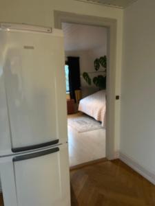 a white refrigerator in a room with a bedroom at BlackberryHouse in Ærøskøbing