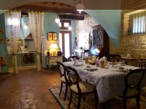 una sala da pranzo con tavolo e sedie bianchi di Vescovado 7 a Gubbio