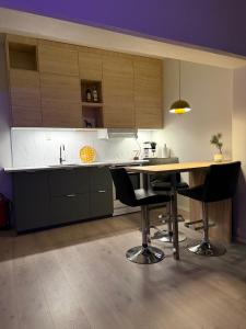a kitchen with a wooden table and black chairs at Askvik Marina Lägenhet i småbåtshamn med havsutsikt in Askvik