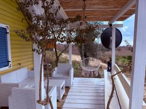 a porch with white furniture on a yellow house at La Belle Saison in Briska Gora