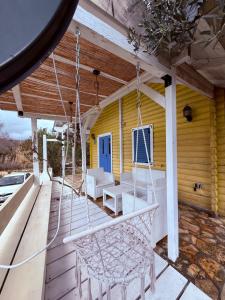 a porch with white chairs and a porch swing at La Belle Saison in Briska Gora
