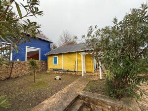 a yellow and blue house with a yard at La Belle Saison in Briska Gora +3 photos