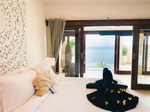 a bedroom with a bed with a view of the ocean at Bali Secrets Oceanfront Villas in Candidasa +88 photos