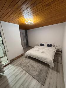 a bedroom with a bed and a wooden ceiling at La Moieciu pe Deal in Moieciu de Jos
