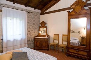 a bedroom with a mirror and a bed and a dresser at La Casetta di Giovanni in Pratovecchio