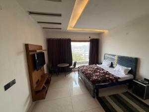 a bedroom with a bed and a tv in a room at Zora apartment in Rohtak