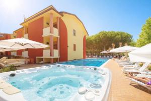 a pool at a resort with chairs and a building at Residence Elisabetta in Cesenatico