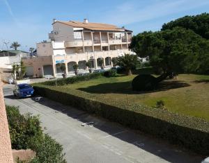 a large building with a car parked in front of it at O'Paloma - appartement T2 au port - Parking - Terrasse in Saint-Cyprien-Plage