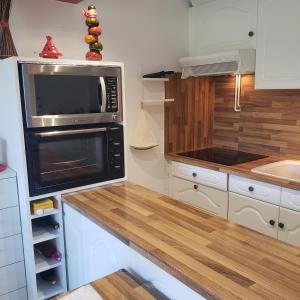 a kitchen with a microwave and a counter top at O'Paloma - appartement T2 au port - Parking - Terrasse in Saint-Cyprien-Plage