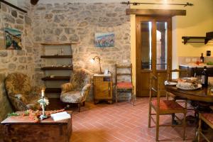 a room with a stone wall with a table and chairs at La Casetta di Giovanni in Pratovecchio