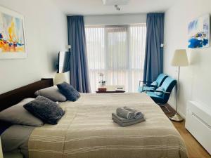 a bedroom with a large bed and a blue chair at Gastenverblijf Buitenplaats Wergea contactloos inchecken in Naarderburen