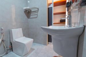 a white bathroom with a sink and a toilet at Elephanto Hotel LTD in Zanzibar City +29 photos