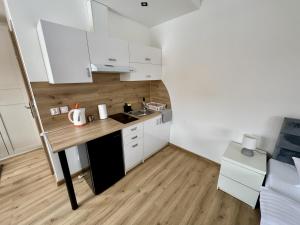 a small kitchen with white cabinets and a wooden counter top at Vitaneo in Vitanová +28 photos