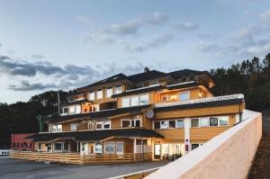 a large wooden building with a lot of windows at Askvik Marina Lägenhet i småbåtshamn med havsutsikt in Askvik